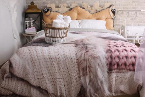 a bed with a blanket and a basket of towels at Апартаменти Studio Amur Creative in Khmelnytskyi