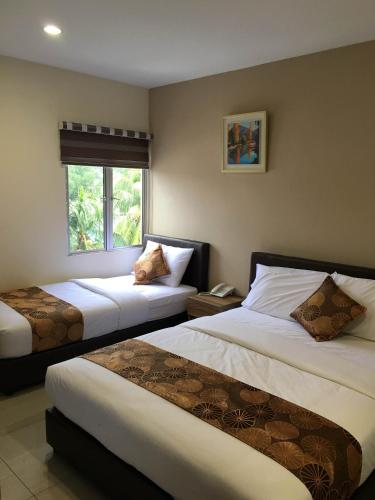 a hotel room with two beds and a window at Soho Hotel Semenyih in Semenyih
