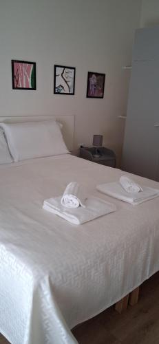 a white bed with two towels on top of it at Affittacamere Risorgimento in Lecco