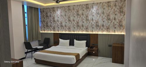 a bedroom with a bed and a desk and a chair at Premvakita restaurant and hotel in Ratlām