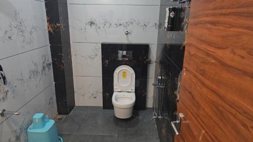 a bathroom with a toilet in a stall at Premvakita restaurant and hotel in Ratlām