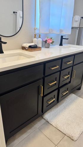 a bathroom vanity with a sink and a mirror at Raider Retreat-Your TTU Basecamp in Lubbock