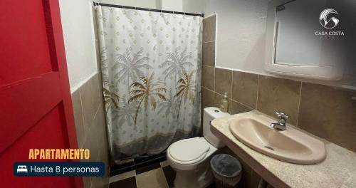 a bathroom with a toilet and a shower curtain at Hotel Casa Costa in Capurganá