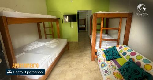 a room with two bunk beds and a hallway at Hotel Casa Costa in Capurganá