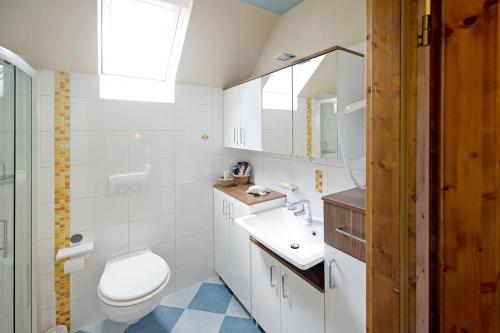 a white bathroom with a toilet and a sink at Charmantes Ferienhaus mit Garten, Kamin & Teich in Hirzenhain