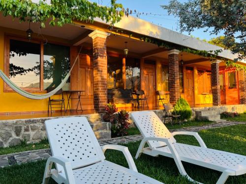 a house with two chairs in front of it at Alojamiento el Abuelo in San Pedro La Laguna