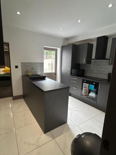 a kitchen with black cabinets and a counter top at Saunders Lodge 4bedroom house sleeps up to 6 in Gillingham