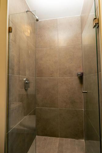 a shower stall with a glass door at Apartment A/C, GYM, Cafeteria | Telmex Auditorium in Guadalajara