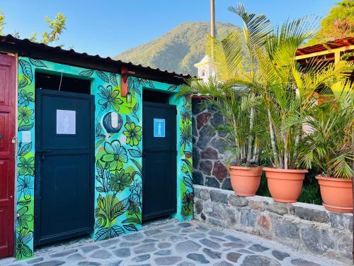 a colorful house with two doors and potted plants at Alojamiento el Abuelo in San Pedro La Laguna