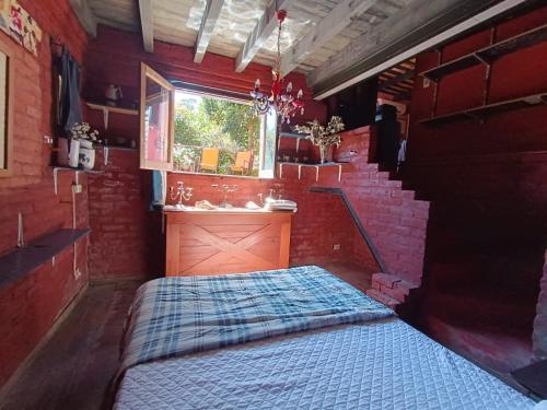 a bedroom with a bed in a room with a window at Estancia Hostel in Colonia del Sacramento
