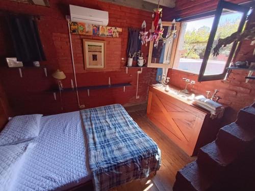 a bedroom with a bed and a sink and a window at Estancia Hostel in Colonia del Sacramento