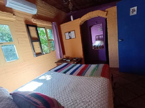 a bedroom with a bed and a blue door at Estancia Hostel in Colonia del Sacramento