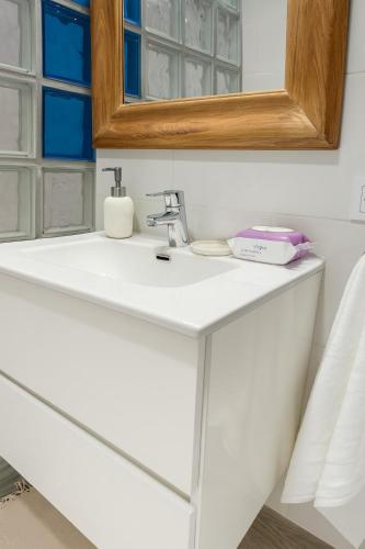 a bathroom with a white sink and a mirror at Bravamar, Playa de Aro, vistas al mar in Platja d'Aro