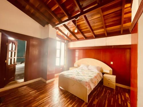 a bedroom with a bed and a wooden floor at Casa de campo x6 de Sayri in Calca