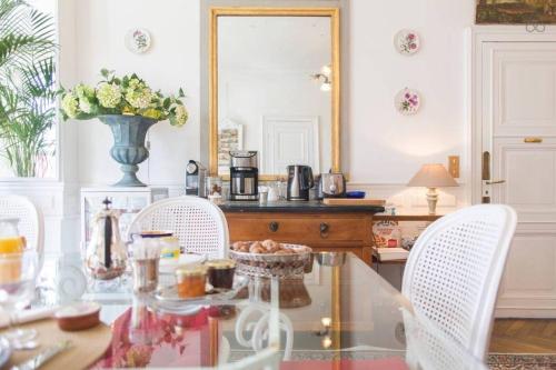 a dining room with a glass table and white chairs at VILLA la GLORIETTE in Rouen