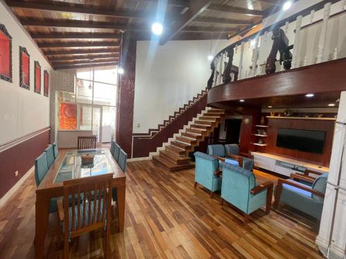 a dining room with a table and chairs and a staircase at Casa de campo x6 de Sayri in Calca