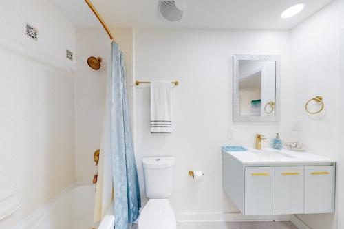 a white bathroom with a toilet and a sink at Luau II 6229 in Destin
