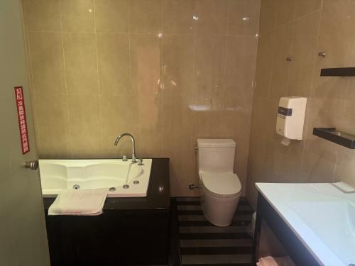 a bathroom with a tub and a toilet and a sink at Fairy Tale City Motel in Hualien City