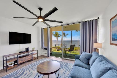 a living room with a blue couch and a flat screen tv at Hale Kai O'Kihei 309 in Kihei