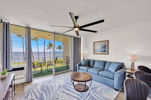 a living room with a blue couch and a view of the ocean at Hale Kai O'Kihei 309 in Kihei