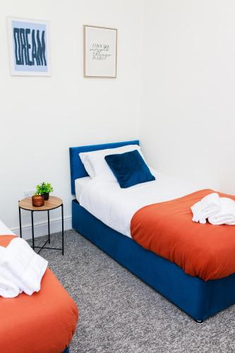 a bedroom with two beds and a side table at Lohia Nights in Middlesbrough