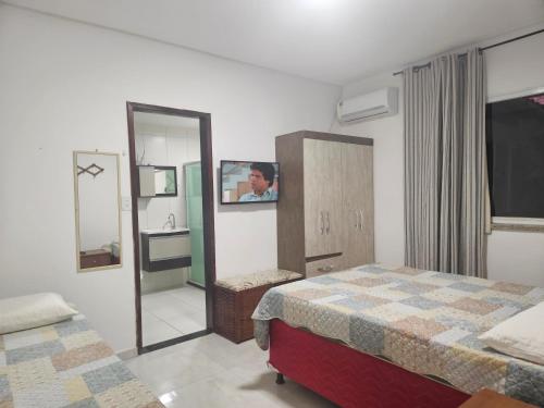 ein Hotelzimmer mit zwei Betten und einem Spiegel in der Unterkunft Casa de Praia Planeta Guarajuba in Guarajuba