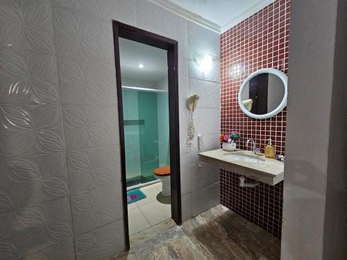 ein Badezimmer mit Toilette, Waschbecken und Spiegel in der Unterkunft Casa de Praia Planeta Guarajuba in Guarajuba