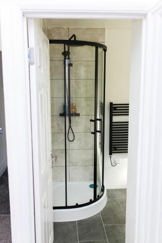 a shower with a glass door in a bathroom at Lohia Nights in Middlesbrough