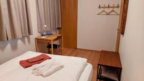 a bedroom with a bed and a small table at Túnfífill Guesthouse - free hot tub and sauna, cozy and quiet in Hvammstangi