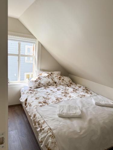 a bed in a room with a window at Nyrenovert Bergenshus med 2 leiligheter - rolig smau i hjertet av Bergen in Bergen