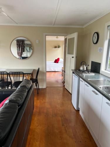 a kitchen and living room with a couch and a table at Tipi and Bobs Waterfront Lodge in Tryphena
