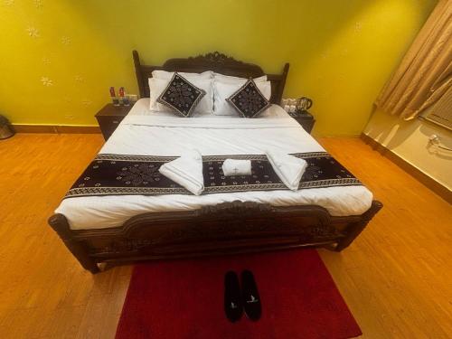 a bedroom with a bed with black shoes on it at JK Rooms 149 Thakur Galaxy in Nagpur