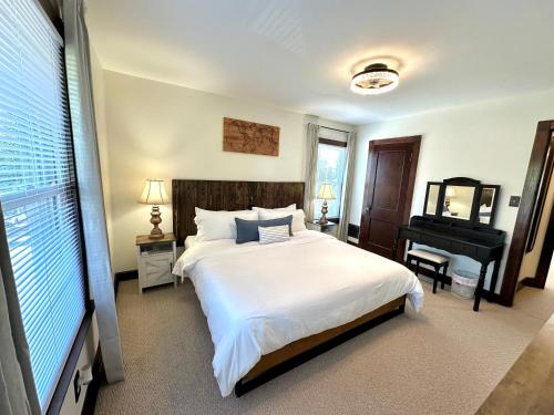 a bedroom with a large white bed and a piano at The Dayton DreamHouse in Dayton