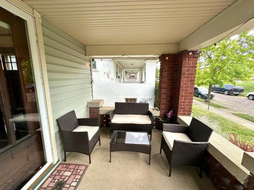 a patio with chairs and a table on a porch at The Dayton DreamHouse in Dayton