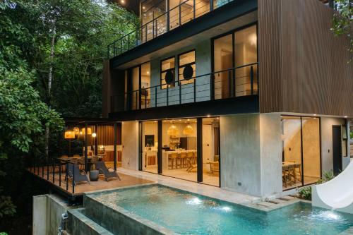 an exterior view of a house with a swimming pool at Manuel Antonio Tree House VIllas in Quepos