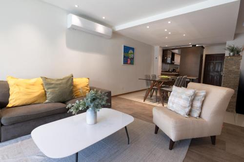 una sala de estar con un sofá y una mesa en Eagle Beach Steps Away Home, en Palm-Eagle Beach