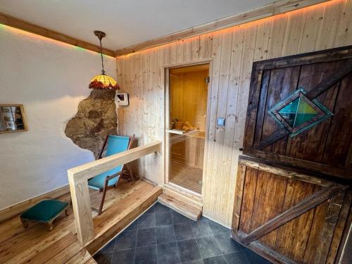 a room with a wooden wall with a wooden door at Cottage With Sauna, Pub & Terrace in Płóczki Górne