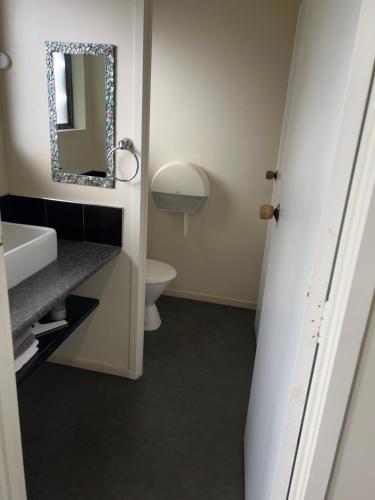 a bathroom with a sink and a mirror at Tipi and Bobs Waterfront Lodge in Tryphena