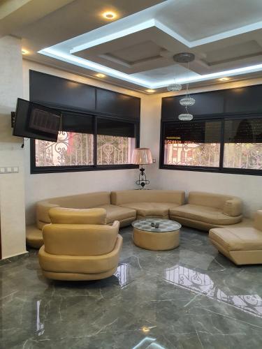 un soggiorno con divani in pelle e TV di Villa entière a Azemmour