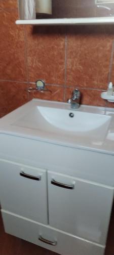 a white bathroom sink with a mirror above it at Stamenkovic apartman in Vranje