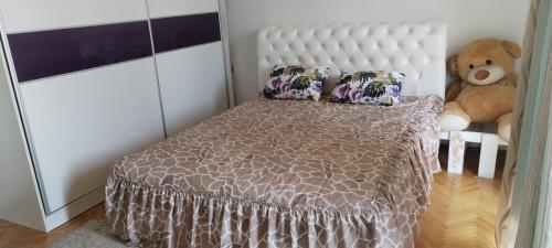 a bedroom with a bed and a teddy bear at Stamenkovic apartman in Vranje