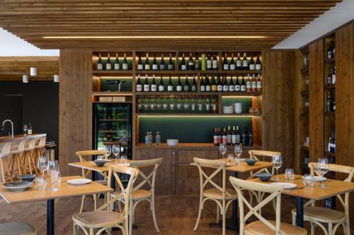 a restaurant with wooden tables and chairs and wine bottles at Quinta da Amendoeira - Évora - The Farmhouse in Évora