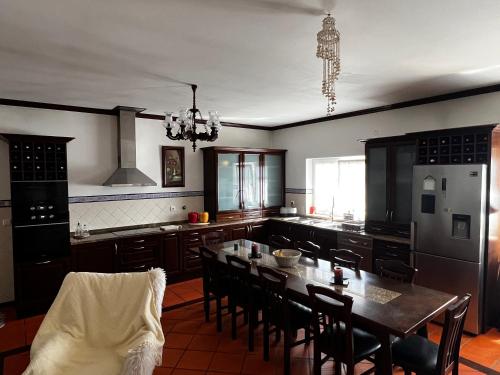 a kitchen with a table and chairs and a kitchen with black appliances at Vagos Guest House in Vagos