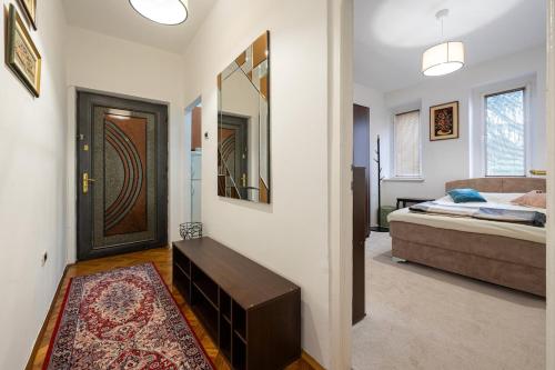 a room with a bed and a door with a mirror at Downtown Apartment Freedom in Podgorica