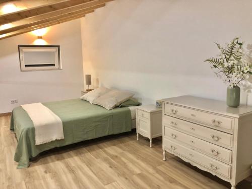 Un dormitorio con una cama y una cómoda. en Zeca Holidays -Atalaia Fall Mezanine Ideal para trabalhar, en Lourinhã