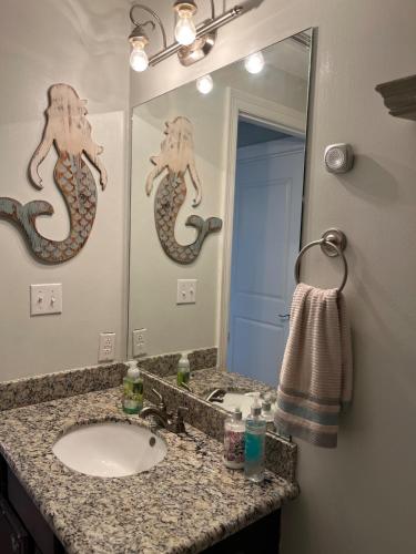 a bathroom with a sink and a mirror at Beachside 1st Floor Condo in Pass Christian