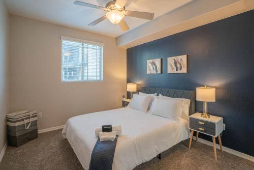 a bedroom with a white bed and a ceiling fan at Luxurious 3BD - Gym, W-D, Parking - Sleeps 8 in Tempe