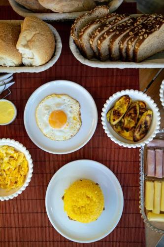 a table topped with plates of eggs and bread at Pousada Vila Sossego in Lençóis