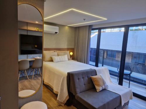 a hotel room with a bed and a mirror at Flat 410 Luxo com Varanda e Vista Mar l Frente Mar Orla de Cabo Branco I Setai Edition in João Pessoa