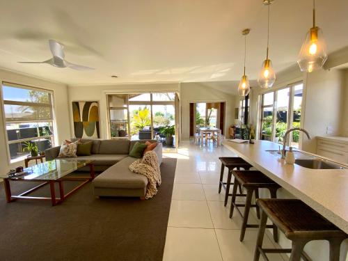 a kitchen and living room with a couch and a table at Large Mt Maunganui Family Villa in Mount Maunganui